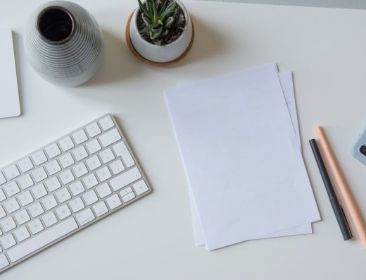 white printer paper beside white apple keyboard